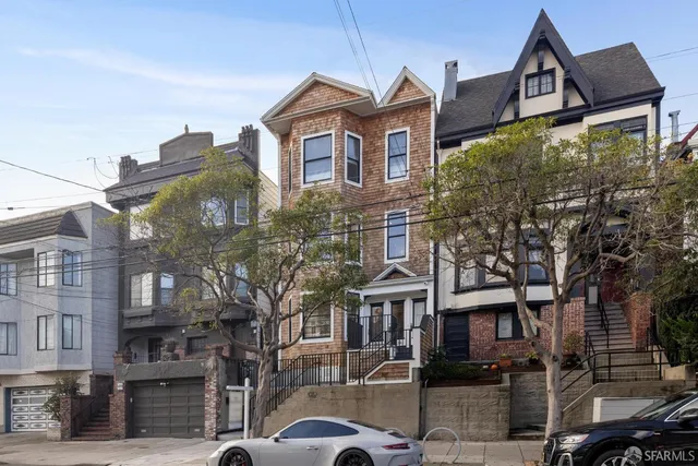 a living room with stainless steel appliances furniture a dining table wooden floor and a kitchen view