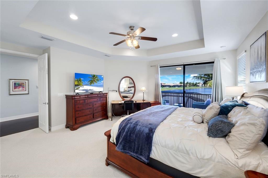 2735 Cinnamon Bay Circle Naples, FL 34119 - Photo 21 of 50 a bedroom with a bed large window and a chandelier