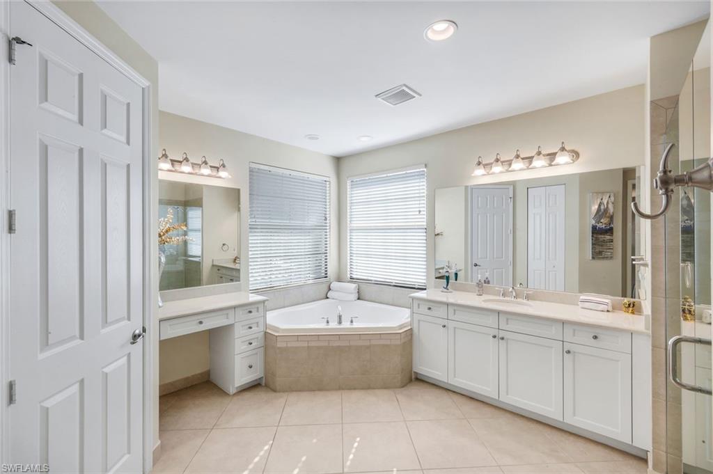 2735 Cinnamon Bay Circle Naples, FL 34119 - Photo 22 of 50 a large bathroom with a double vanity sink mirror and bathtub