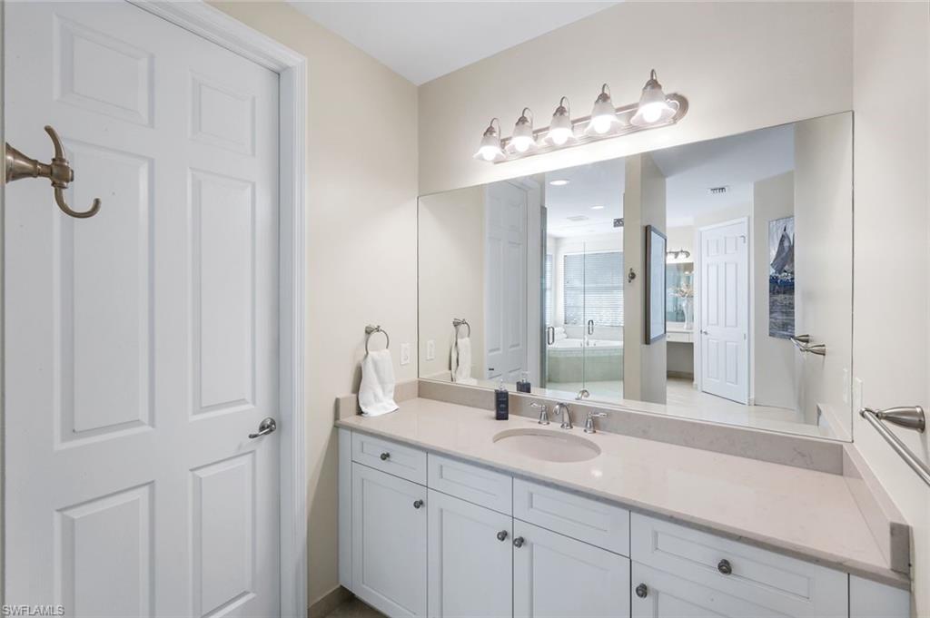 2735 Cinnamon Bay Circle Naples, FL 34119 - Photo 24 of 50 a bathroom with a double vanity sink and a mirror