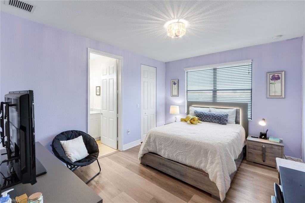 2735 Cinnamon Bay Circle Naples, FL 34119 - Photo 28 of 50 a bedroom with a bed and a chandelier