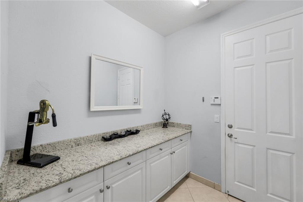 2735 Cinnamon Bay Circle Naples, FL 34119 - Photo 35 of 50 a bathroom with a granite countertop sink and a mirror