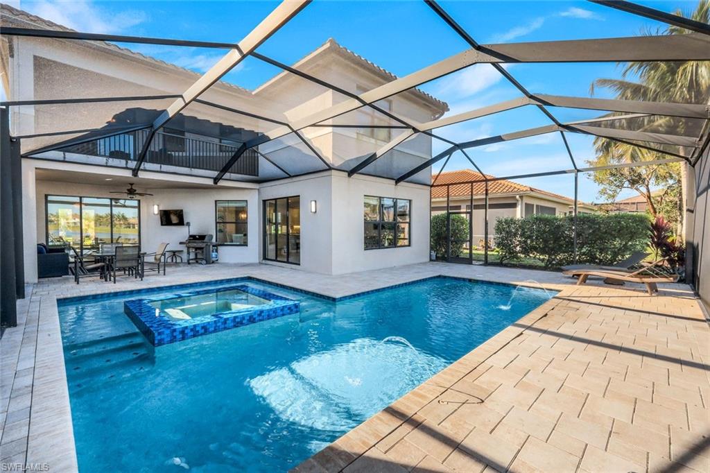 2735 Cinnamon Bay Circle Naples, FL 34119 - Photo 39 of 50 a view of a patio with table and chairs under an umbrella