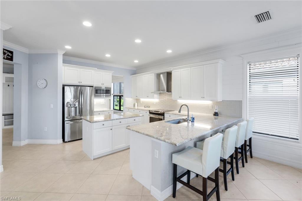 2735 Cinnamon Bay Circle Naples, FL 34119 - Photo 10 of 50 a kitchen with refrigerator and chairs