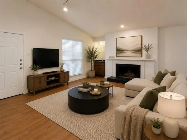 a living room with furniture a flat screen tv and a fireplace