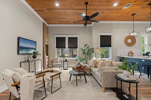 a living room with furniture a flat screen tv and kitchen view