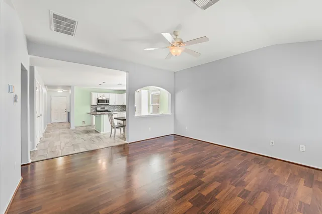 a view of a livingroom with wooden floor and a ceiling fan