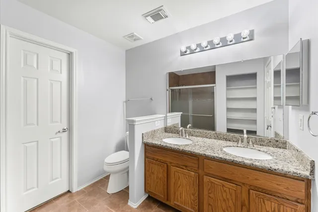 a bathroom with a granite countertop sink mirror and toilet