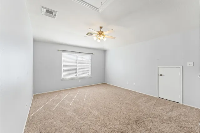 a view of a room with a ceiling fan and a window