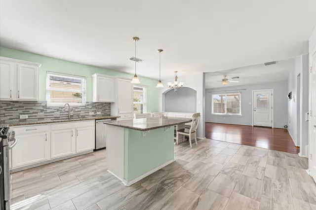 a kitchen with a sink cabinets and wooden floor