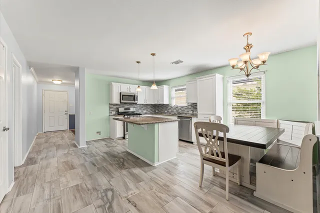 a kitchen with granite countertop white cabinets and stainless steel appliances