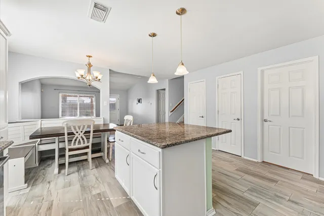 a spacious kitchen with stainless steel appliances granite countertop a stove and a wooden floors