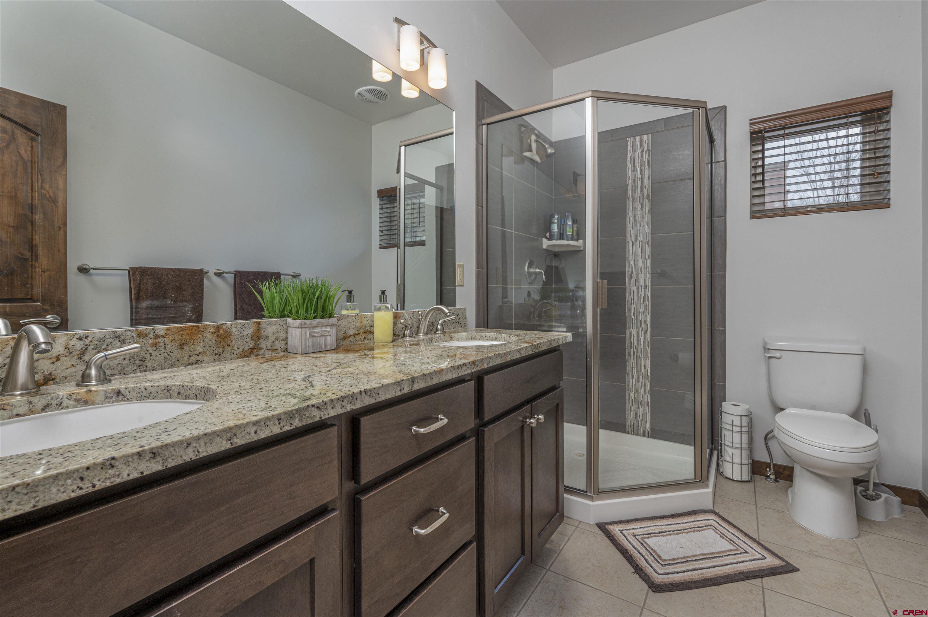 1422 Animas View Drive, Unit 24 Durango, CO 81301 - Photo 11 of 23 a bathroom with a granite countertop sink toilet and shower