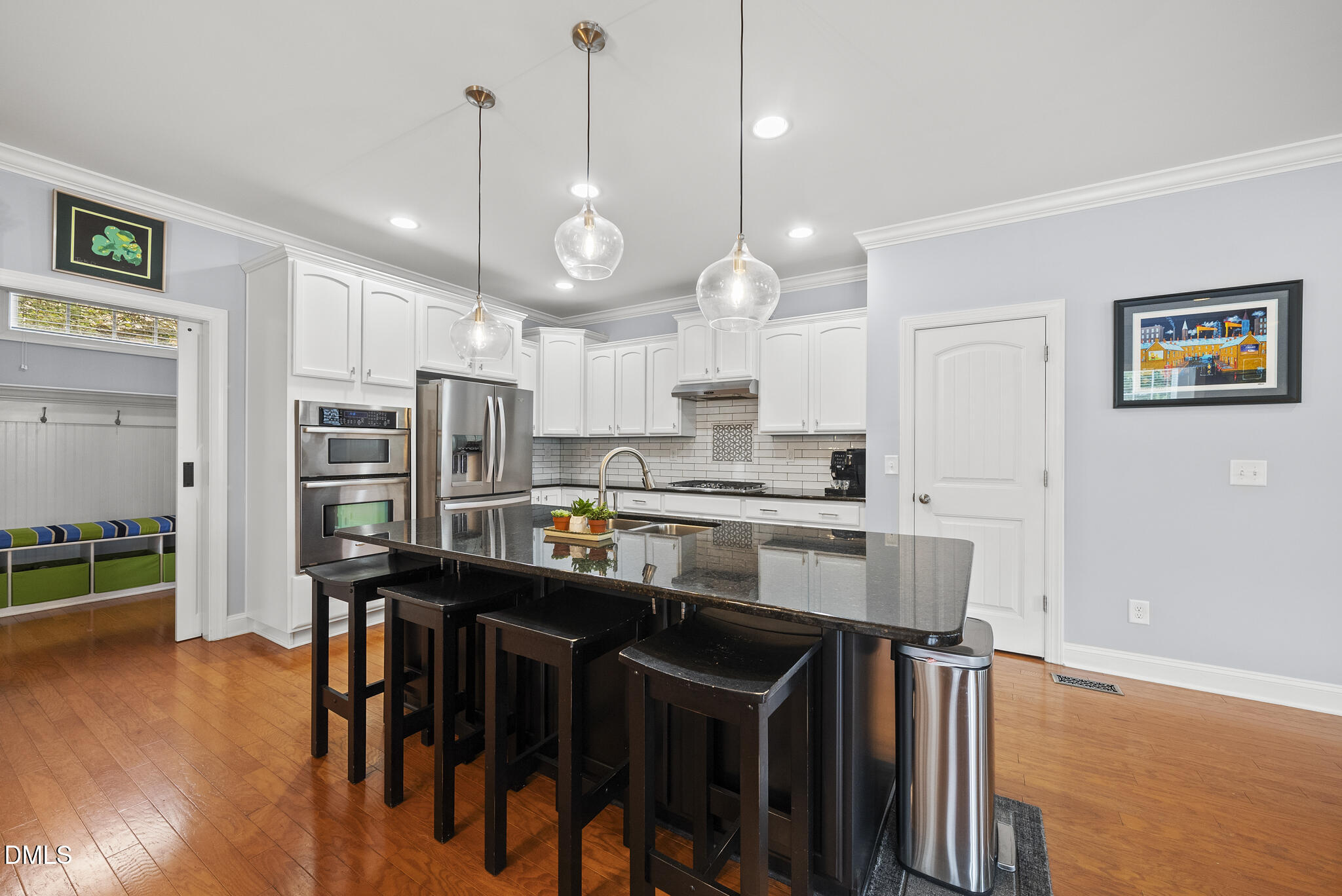 424 Powers Ferry Road Cary, NC 27519 - Photo 20 of 88 a kitchen with stainless steel appliances granite countertop a stove top oven a sink a dining table and chairs with wooden floor