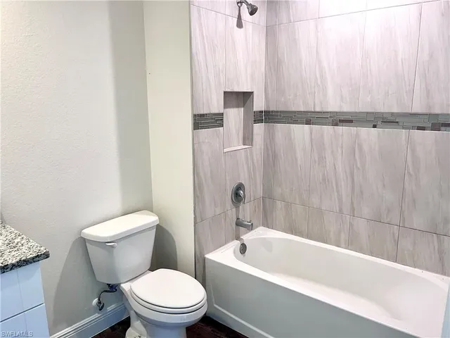 a white toilet sitting next to a bathtub