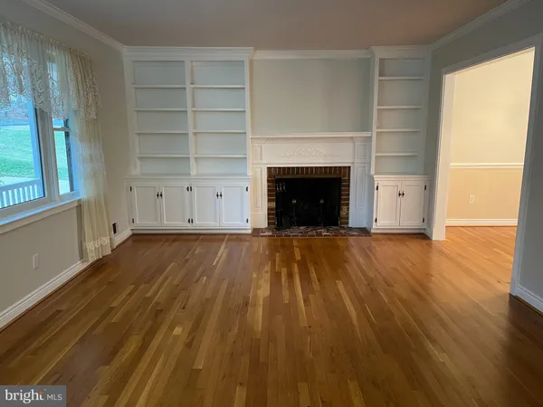 a view of a room with wooden floor and chandelier