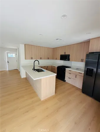 a kitchen with a sink a counter top space cabinets and stainless steel appliances
