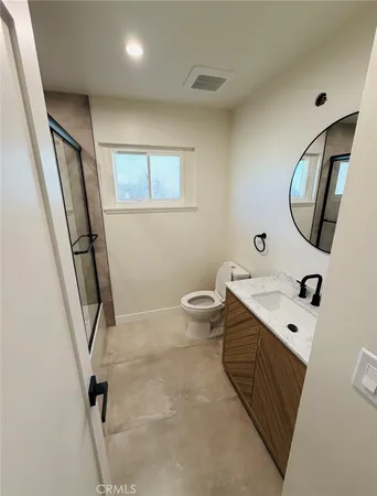 a bathroom with a sink a toilet and a mirror