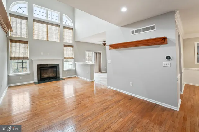 a view of empty room with wooden floor and fireplace