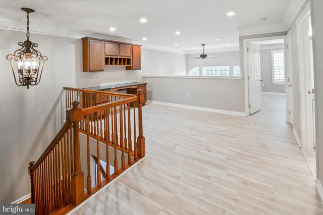 a view of a hallway with wooden floor and windows