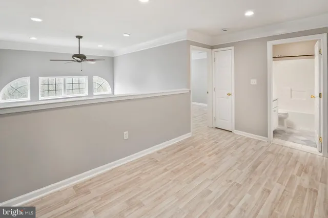 a view of empty room with wooden floor and window