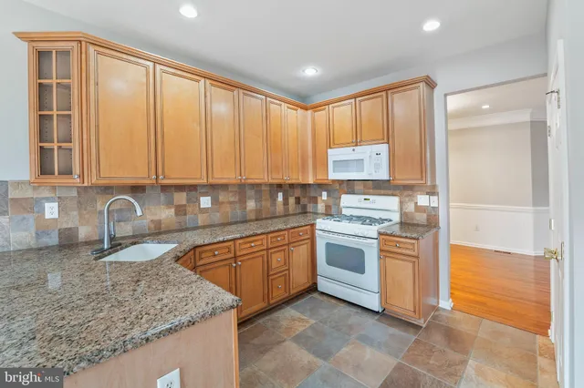 a kitchen with stainless steel appliances granite countertop a sink stove and cabinets