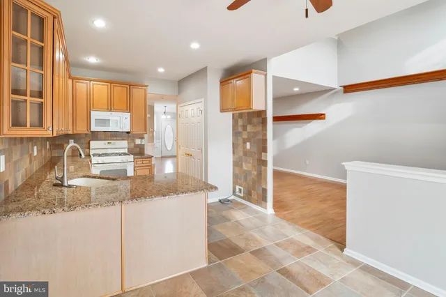 a view of a kitchen with kitchen island a counter top space cabinets and stainless steel appliances