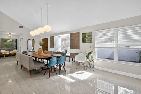 a kitchen with stainless steel appliances kitchen island granite countertop a dining table chairs and view of living room