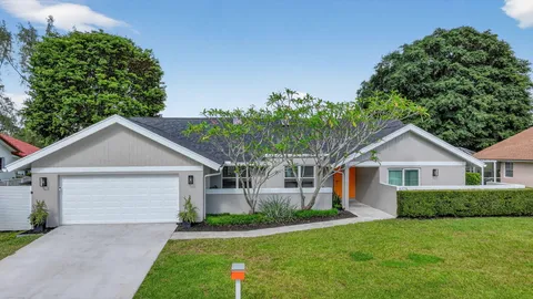 a front view of a house with a garden and plants