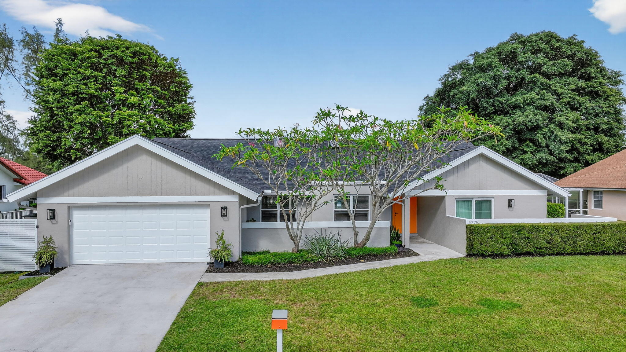 4275 Fox Trace Road Boynton Beach, FL 33436 - Photo 2 of 69 a front view of a house with a garden and plants