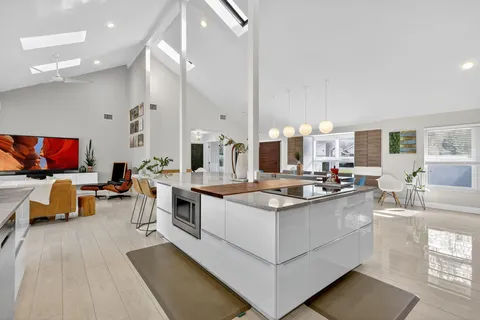 a living room with furniture and a view of kitchen