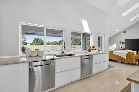 a kitchen with granite countertop a refrigerator and a sink