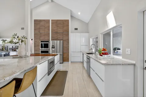 a kitchen with stainless steel appliances granite countertop a sink and a refrigerator