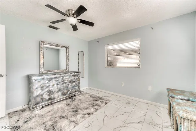 a view of a livingroom with a chandelier fan and wooden floor