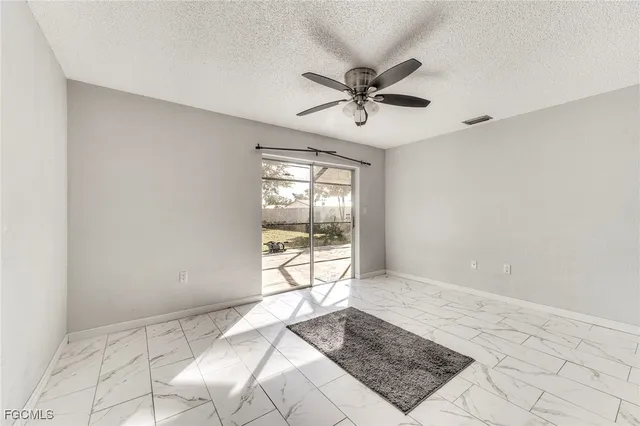 a view of a hallway with wooden floor and a kitchen space