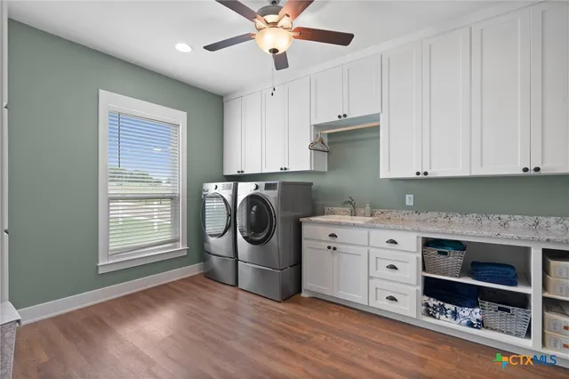 a kitchen with stainless steel appliances granite countertop a stove a sink and a refrigerator with wooden floors