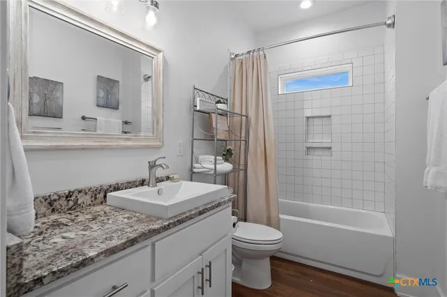 a bathroom with a granite countertop sink toilet and shower