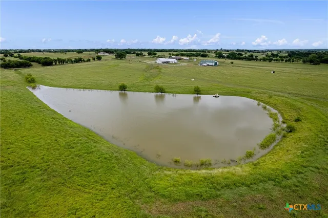 an aerial view of a residential houses with outdoor space and river