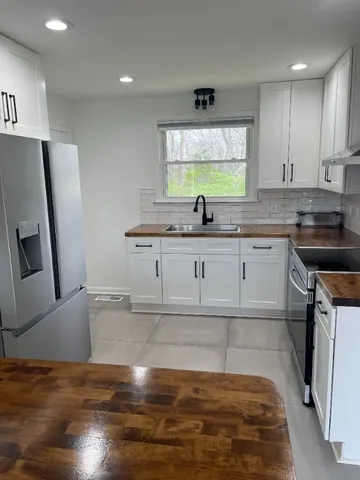 a kitchen with kitchen island granite countertop a sink cabinets and wooden floor
