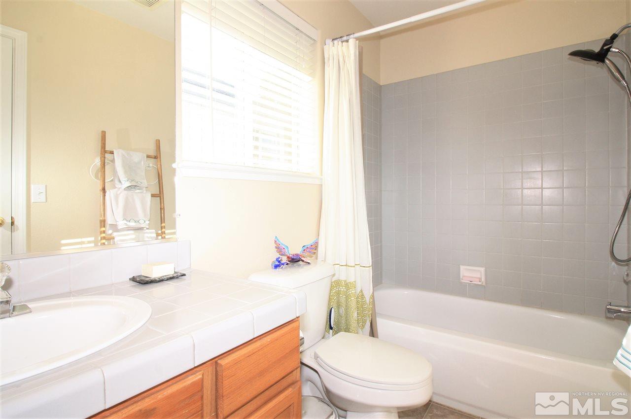 470 Len Circle Reno, NV 89511 - Photo 17 of 24 a bathroom with a granite countertop sink toilet tub and shower