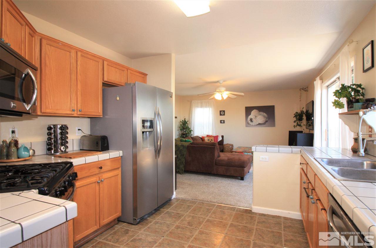 470 Len Circle Reno, NV 89511 - Photo 5 of 24 a kitchen with stainless steel appliances kitchen island granite countertop a refrigerator stove top oven and sink