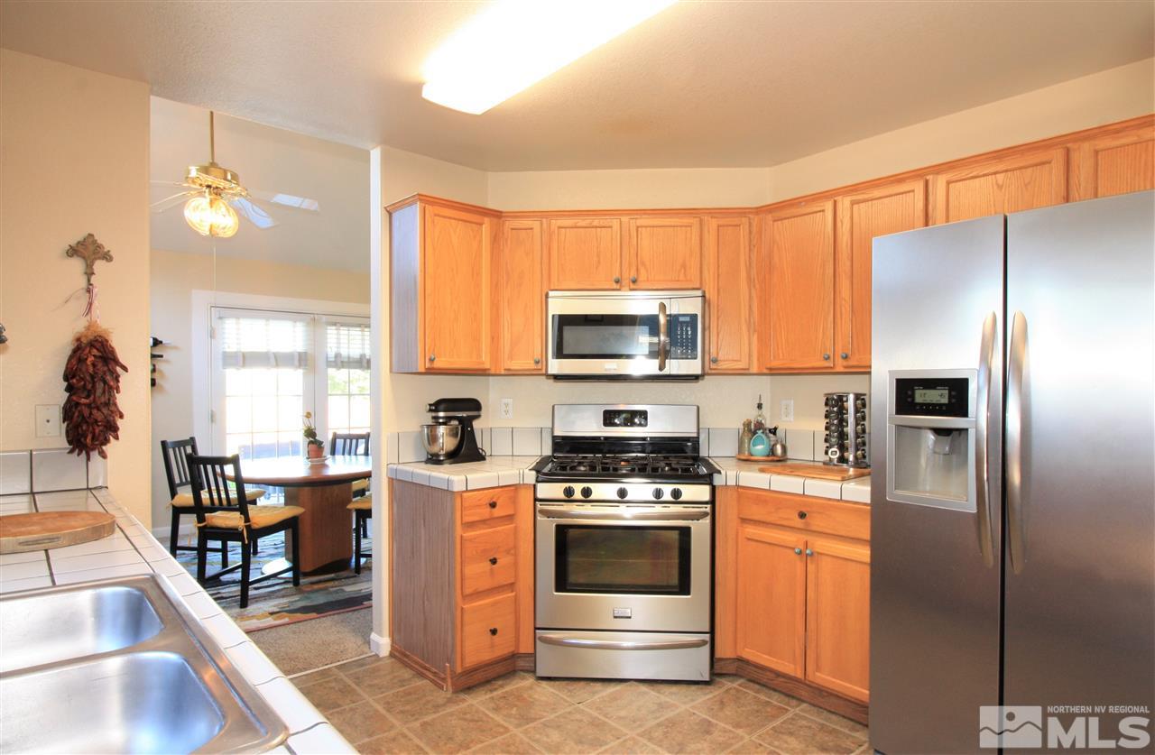 470 Len Circle Reno, NV 89511 - Photo 6 of 24 a kitchen with stainless steel appliances a stove a refrigerator a sink a stove and cabinets
