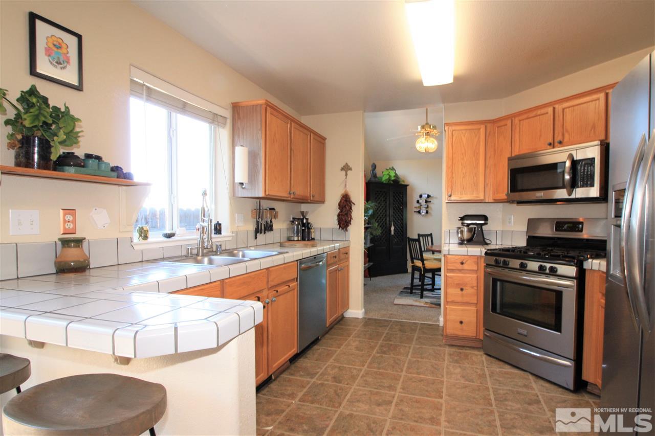 470 Len Circle Reno, NV 89511 - Photo 7 of 24 a large kitchen with stainless steel appliances granite countertop a stove a sink and a microwave
