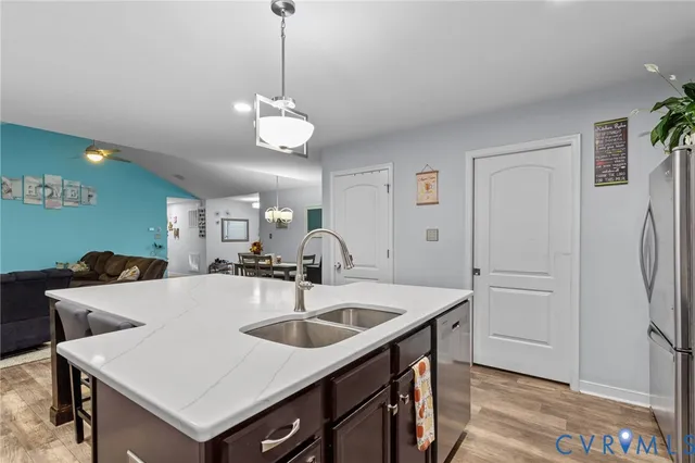 a kitchen with stainless steel appliances a sink a refrigerator a counter top space and cabinets