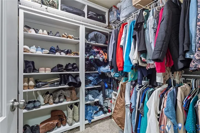 a view of walk in closet with clothes and shoes