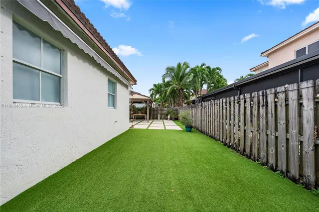 a view of a house with backyard and sitting area
