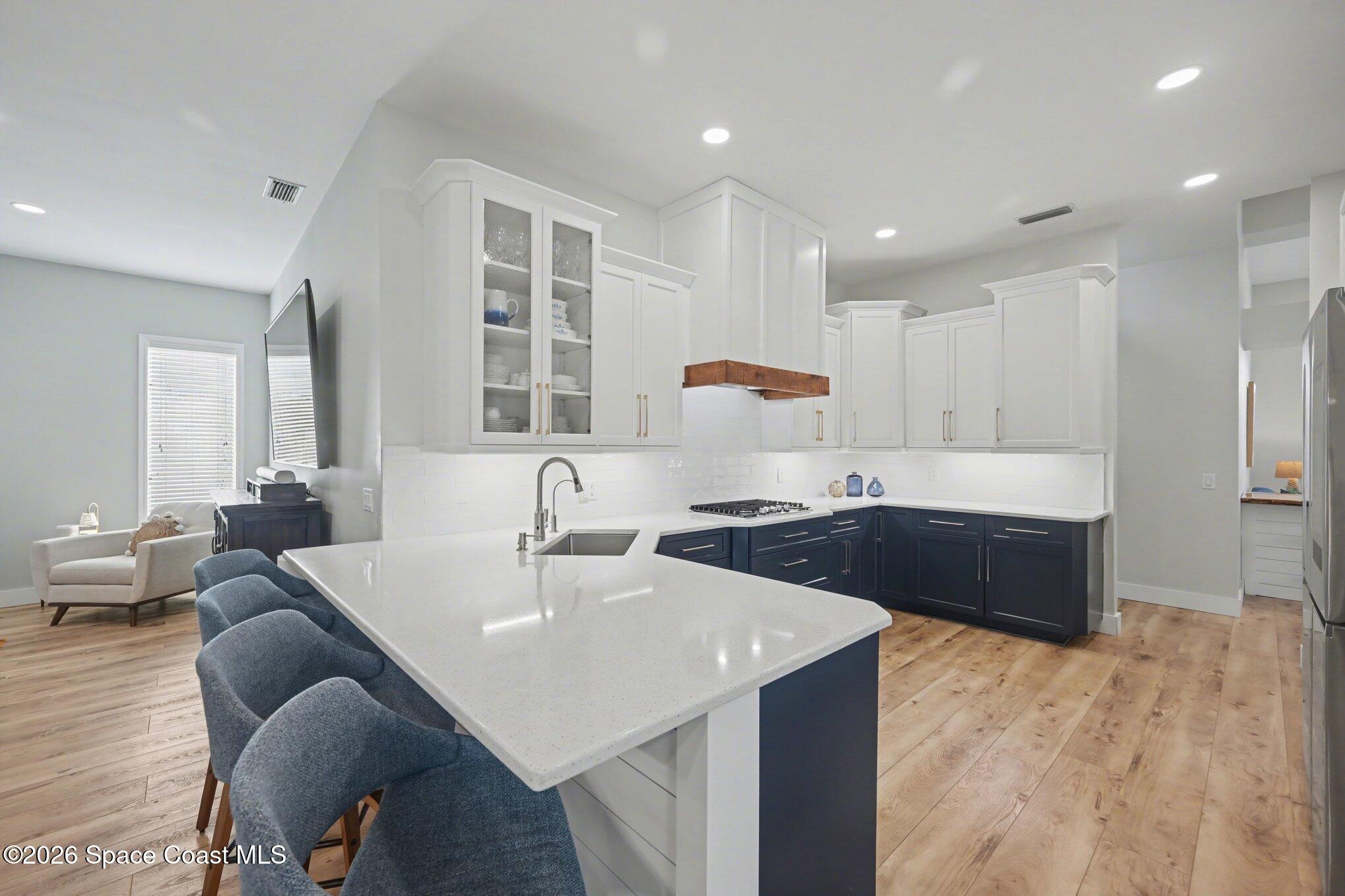 140 Utopia Circle Merritt Island, FL 32952 - Photo 12 of 55 a large white kitchen with a refrigerator a sink dishwasher a stove and a dining table with wooden floor