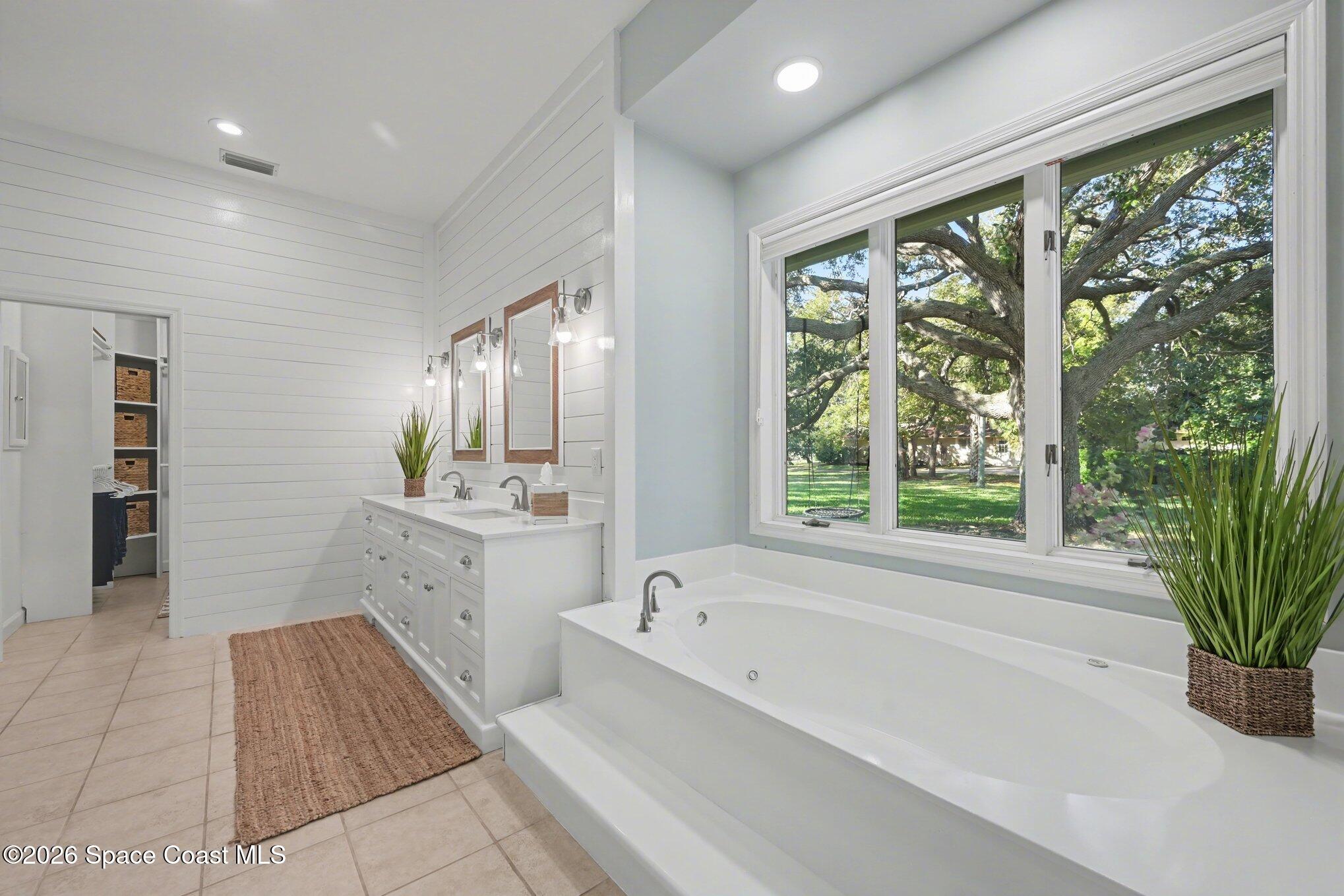 140 Utopia Circle Merritt Island, FL 32952 - Photo 19 of 55 a spacious bathroom with a tub a potted plant and a sink