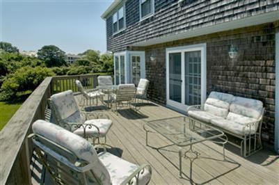 61 Shore Road Chatham, MA 02633 - Photo 4 of 28 a view of a patio with couches table and chairs and potted plants