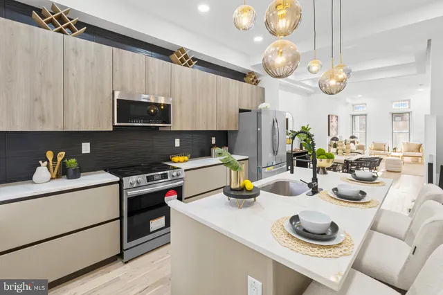 a kitchen with stainless steel appliances a stove a sink and a refrigerator